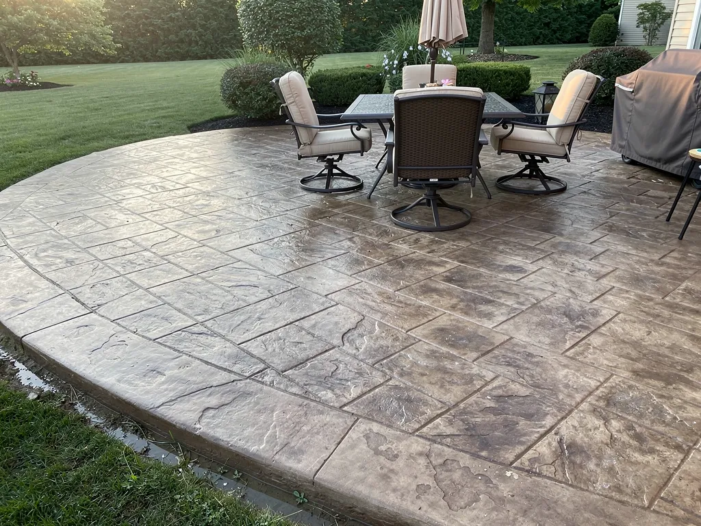 Durable stamped concrete patio slab in a backyard setting