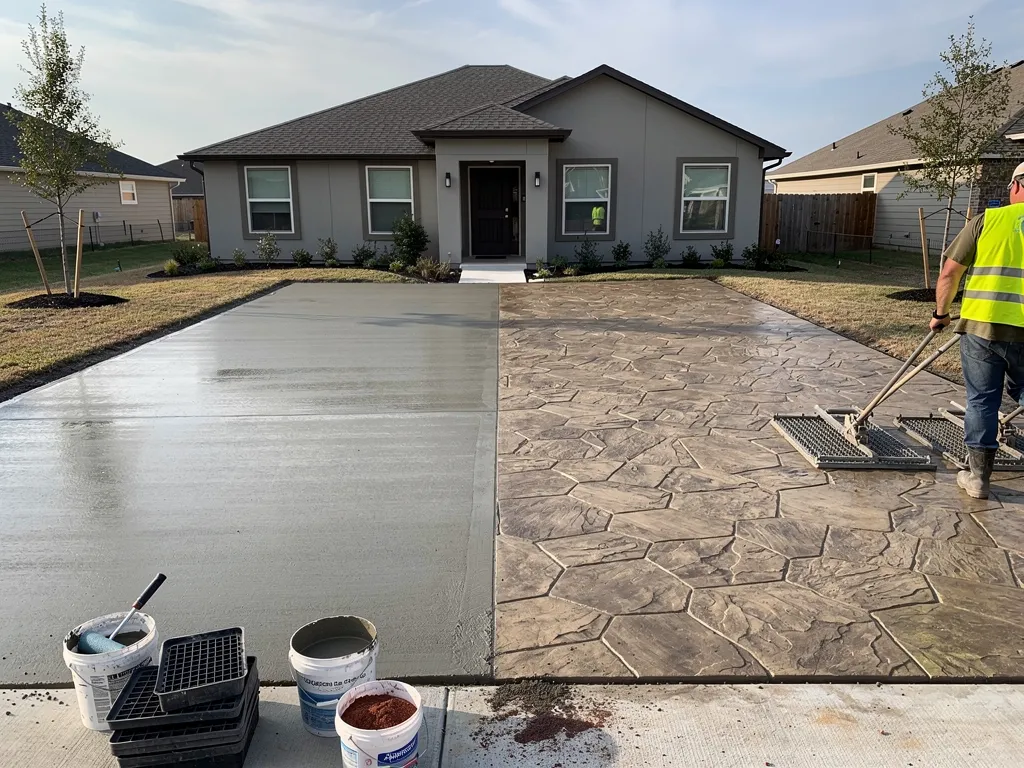 Textured stamped concrete driveway resembling natural stone leading to a home