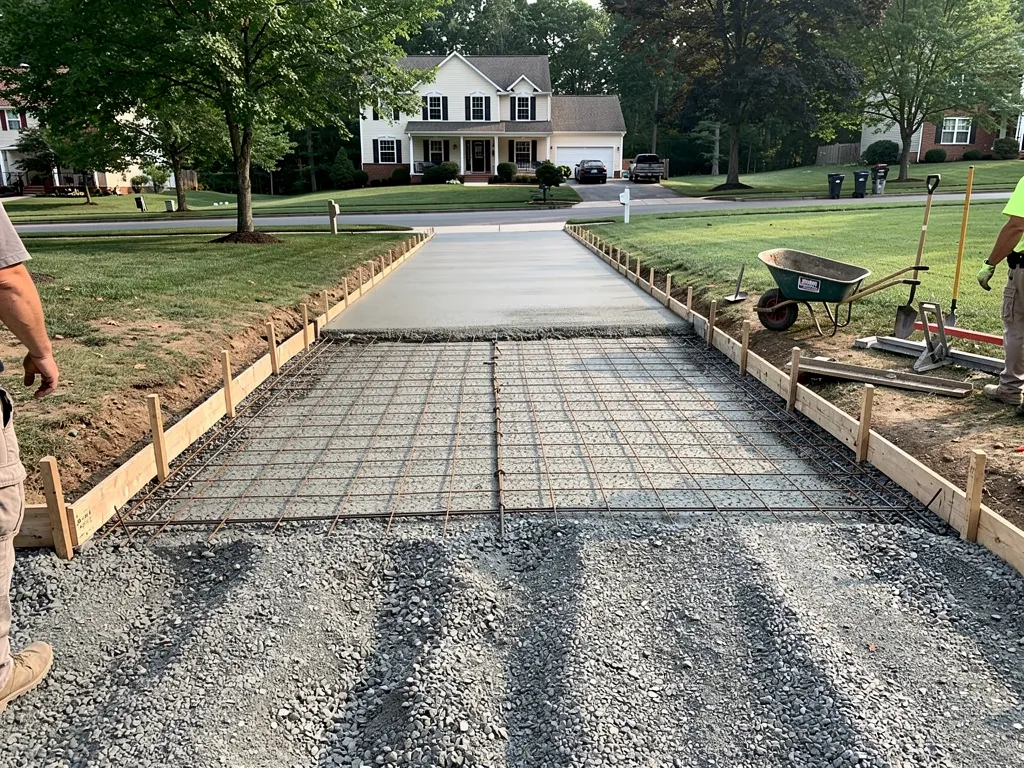 Crew pouring and leveling concrete during driveway installation